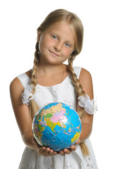 The girl holds the globe collected from puzzle in hands. Selecti