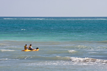 Couple Paddling out to Sea