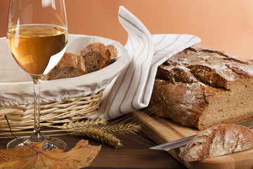 herbstliches stilleben mit wein, brot, ähren, blatt