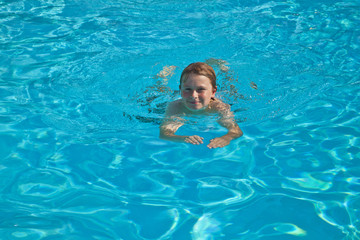 Fototapeta na wymiar child swims in the pool and has fun