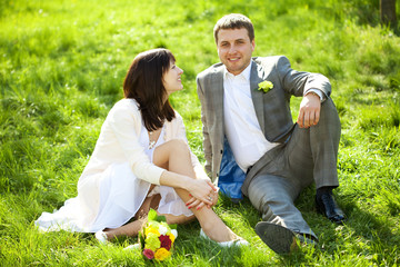 just married in a flowering garden sitting on the grass