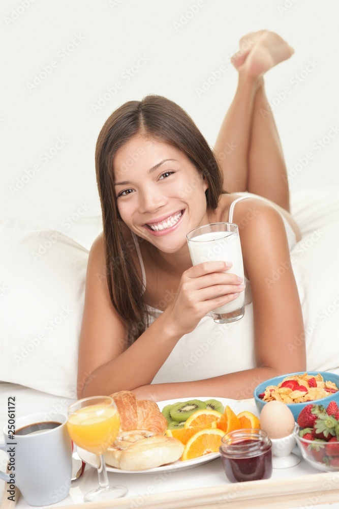 Wall mural Woman eating breakfast in bed