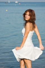 Fototapeta na wymiar Young beautiful woman in a white dress