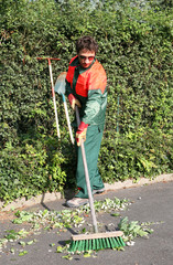 balayage d'espaces verts par un jardinier municipal
