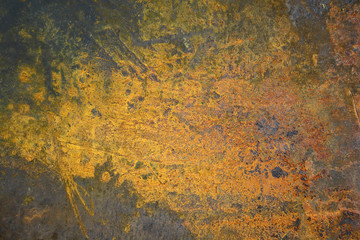 Rusty metal surface with a bright yellow-orange stain
