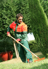 Ratissage de l'herbe par un jardinier employé municipal