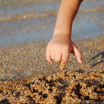 Child Drawing On Sand