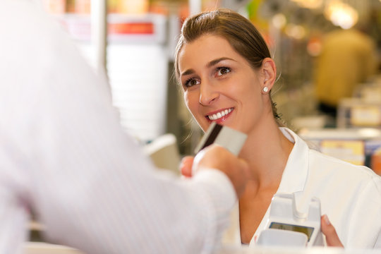 Kassiererin im Supermarkt nimmt Kreditkarte