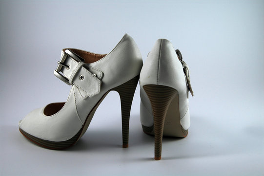 pair of creme-colored high heels with a buckle