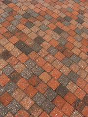 Fototapeta premium speckled red brown orange pink square brick pattern on pavement