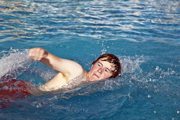 boy is crawling in the pool