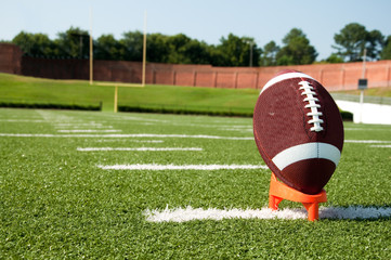 Closeup of American Football on Tee on Field