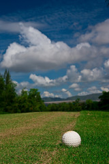 Golfball on course and blue sky