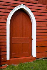 Arched door in old red wooden barn.