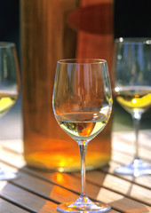 glasses of white wine with a bottle on a wooden table