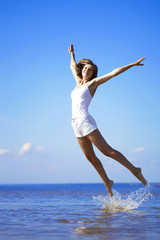 Beautiful girl who jump on the beach