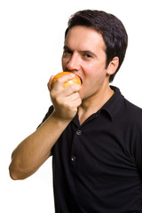 Young man eating a fresh red apple, isolated on white