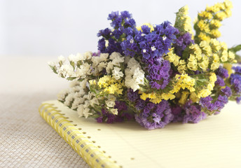 A bunch of immortelles on a copybook lying on the table