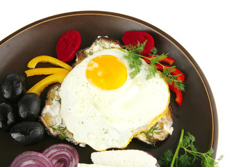 egg on dark plate with vegetables