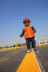 Young Boy Walking on Yellow Line