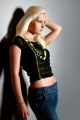 Fototapeta premium Glamorous young woman in shirt and jeans on grey background