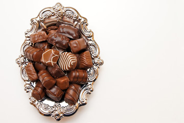 Chocolate candies on a silver platter.