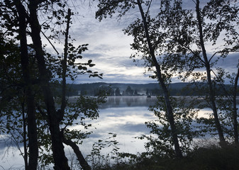 Lake view. Late summer with fog over the horizon.