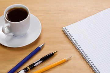 notepad and pens on table