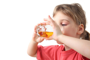 little girl in red shirt holding glass with juice for two hands