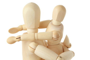 wooden figures of child embracing his parent by shoulders