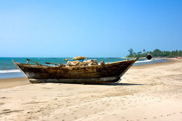 Fototapeta na wymiar Wooden outrigger fishing boat at Asvem beach, India