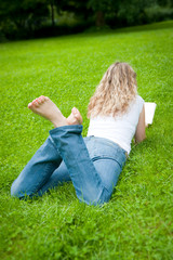 Fototapeta premium Junge Frau mit blonden Locken liest ein Buch