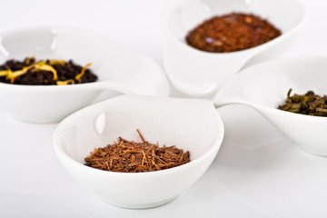 four kinds of tea in small white plates
