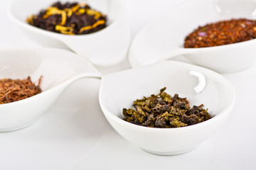 four kinds of tea in small white plates