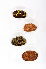 four kinds of tea in small white plates