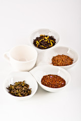 four kinds of tea in small white plates
