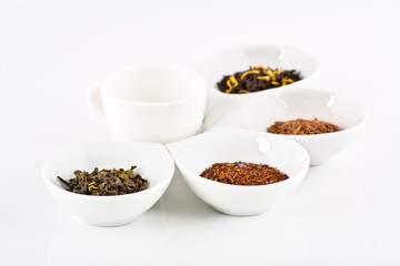 four kinds of tea in small white plates