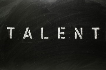 The word TALENT in stencil letters on a blackboard