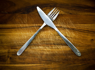 Stainless steel cutlery on a wooden chopping board
