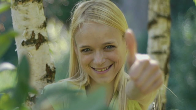 Junges blondes Model im Wald zwischen den B&auml;umen