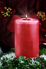 Lit Christmas Candle and Poinsettias