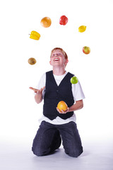 Rothaariger Junge jongliert mit Gemüse und Obst Porträt