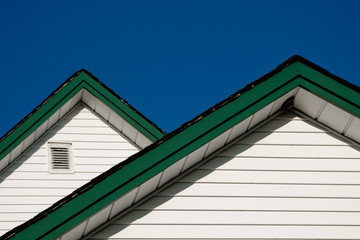 farmhouse roof peaks against a blue sky.