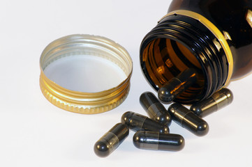 glass jar with black pills