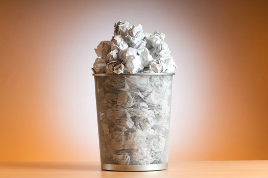 Garbage bin with paper waste isolated on white