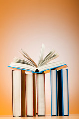 Stack of text books against gradient background