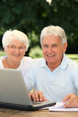 Senior couple at home surfing on internet