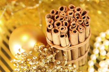 Ein Bündel Zimtstangen mit goldener Weihnachtsdekoration