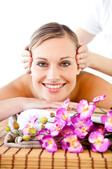 Obraz na płótnie Canvas Pretty woman with flowers enjoying a head massage