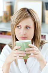 Charming caucasian blond woman enjoying her coffee in the kitche